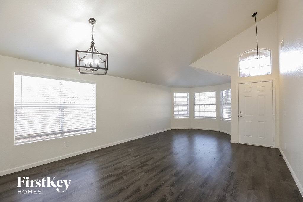 an empty living room with wood floors and a white door