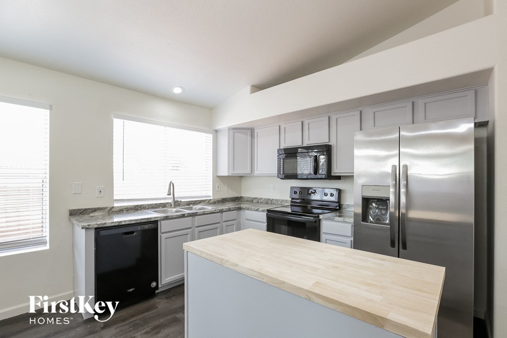 a kitchen with white cabinets and stainless steel appliances and a counter top