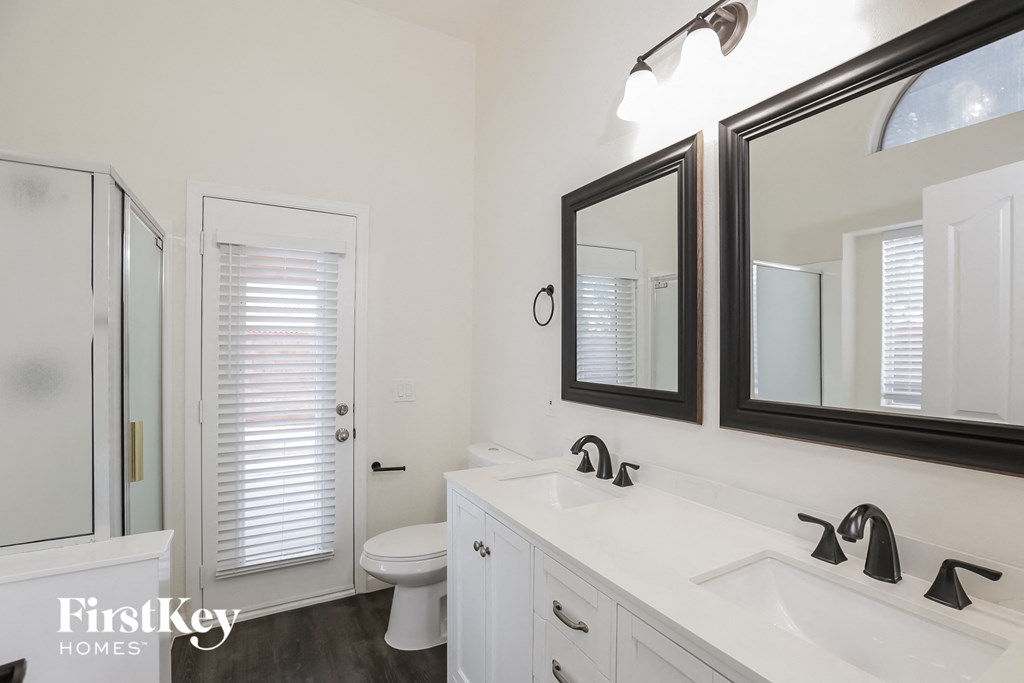 a bathroom with two mirrors and a sink and a toilet