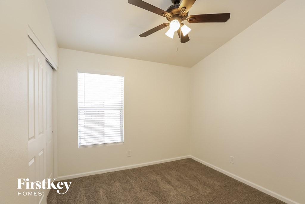 a bedroom with carpet and a ceiling fan