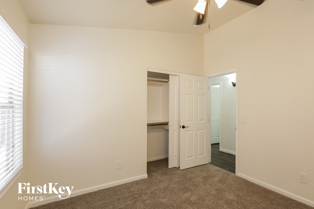 a bedroom with a closet and a door to the bathroom