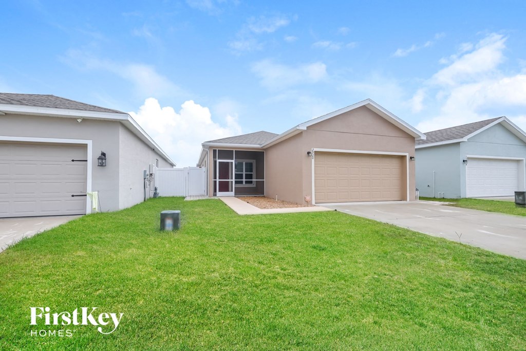 A row of houses with the logo "FirstKey Homes" on the grass in front.