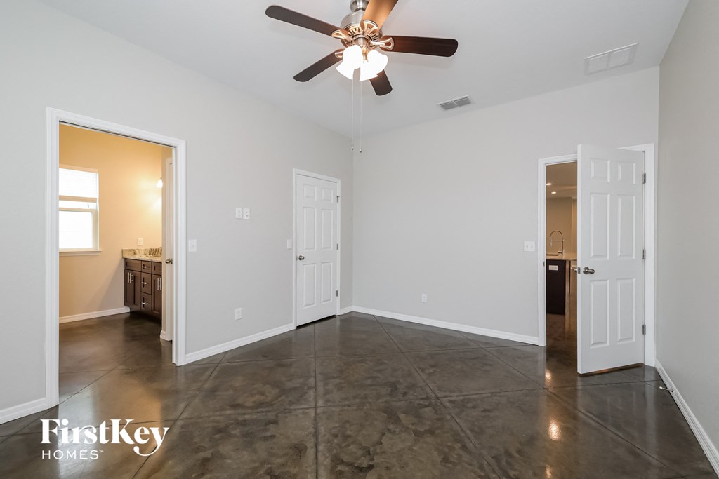 A spacious room with a ceiling fan and a tiled floor.