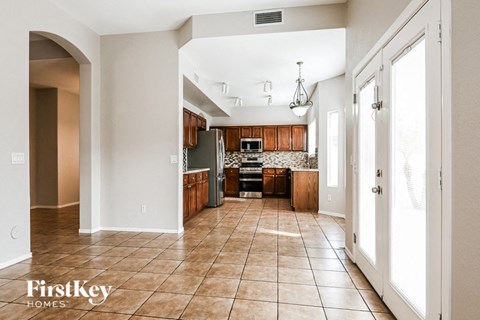 a kitchen with wooden cabinets and tile flooring