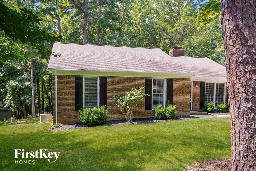 A brick house with a tree in front of it.