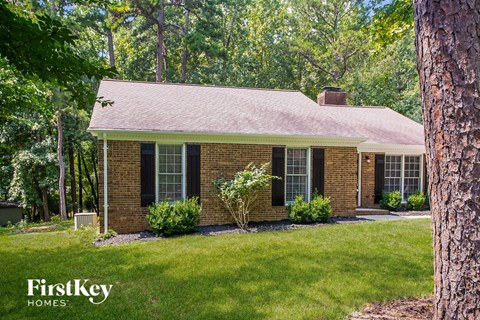A brick house with a tree in front of it.