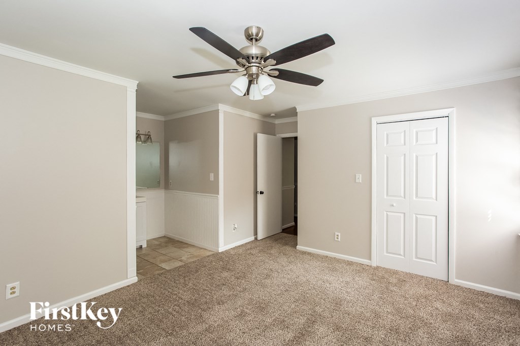 A room with a ceiling fan and a door.