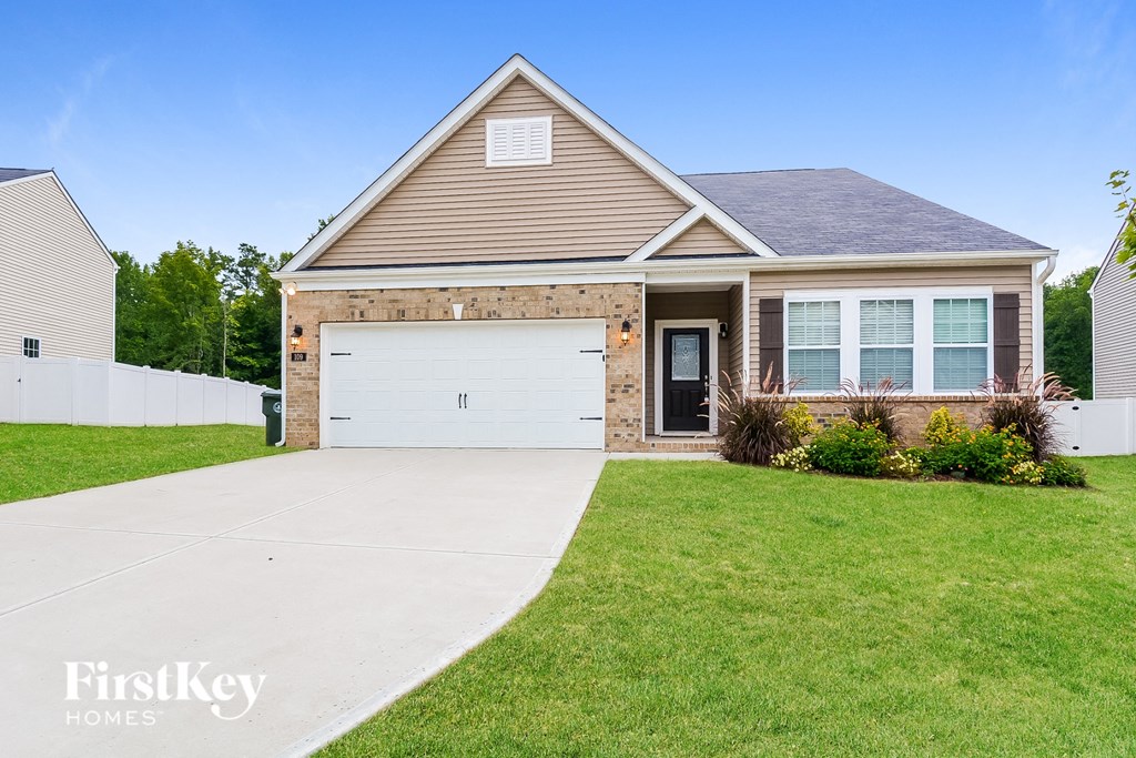 a brick house with a white garage door in front of a lawn