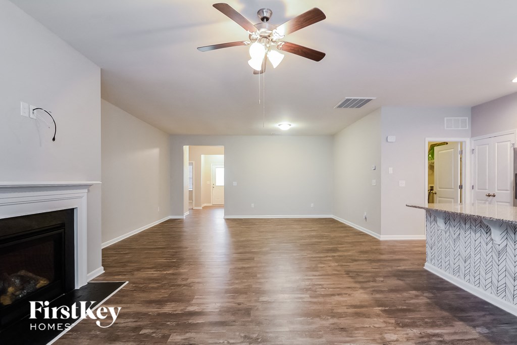 a living room with a fireplace and a ceiling fan