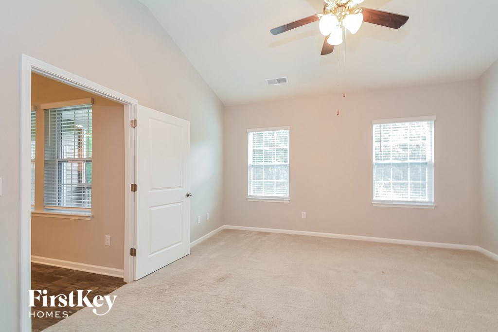 a bedroom with a ceiling fan and a white door