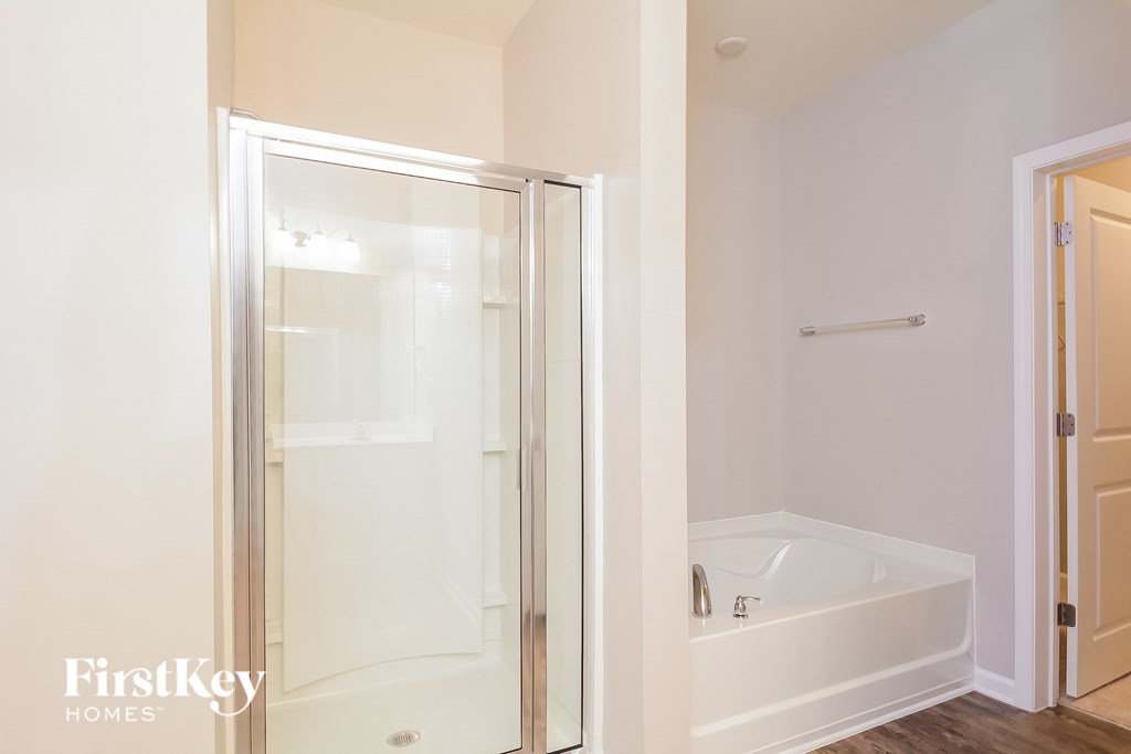 a white bathroom with a shower and a white tub