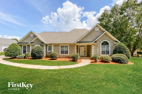 a home with a lawn and a sidewalk in front of it