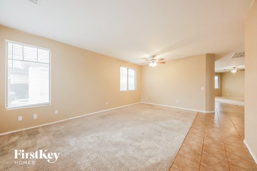 a empty living room with a ceiling fan and a large window