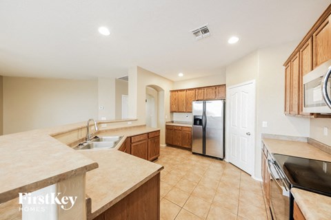 a large kitchen with a sink and a refrigerator