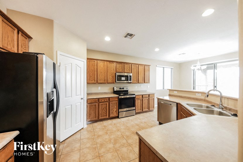 a large kitchen with stainless steel appliances and wooden cabinets