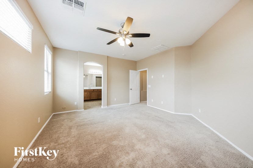 an empty living room with a ceiling fan