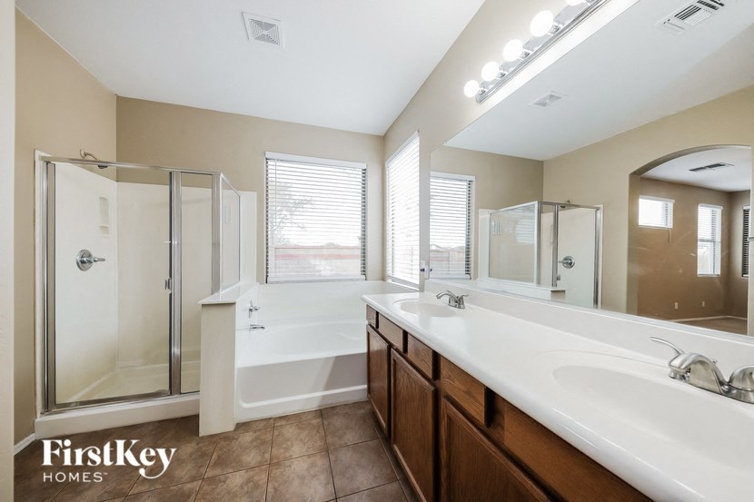 a bathroom with two sinks and a tub and a shower