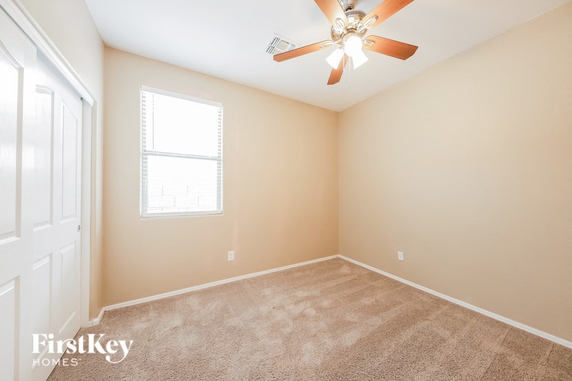 a empty room with a ceiling fan and a window