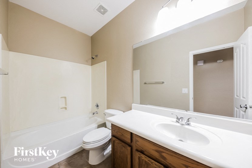 a bathroom with a sink toilet and tub and a mirror