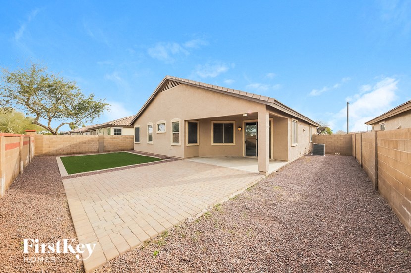 a home with a brick driveway and a house next to it