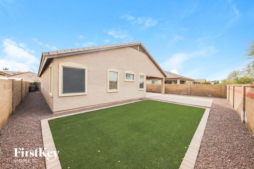 a backyard with a green lawn and a house