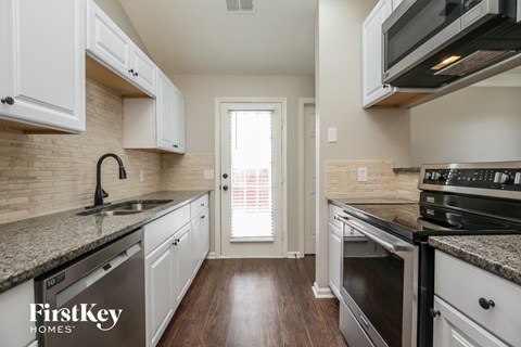 A kitchen with a sink, stove, and oven.