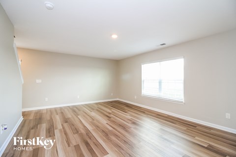 the living room with hardwood floors and a large window
