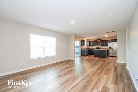 a kitchen and living room with wood flooring and a large window
