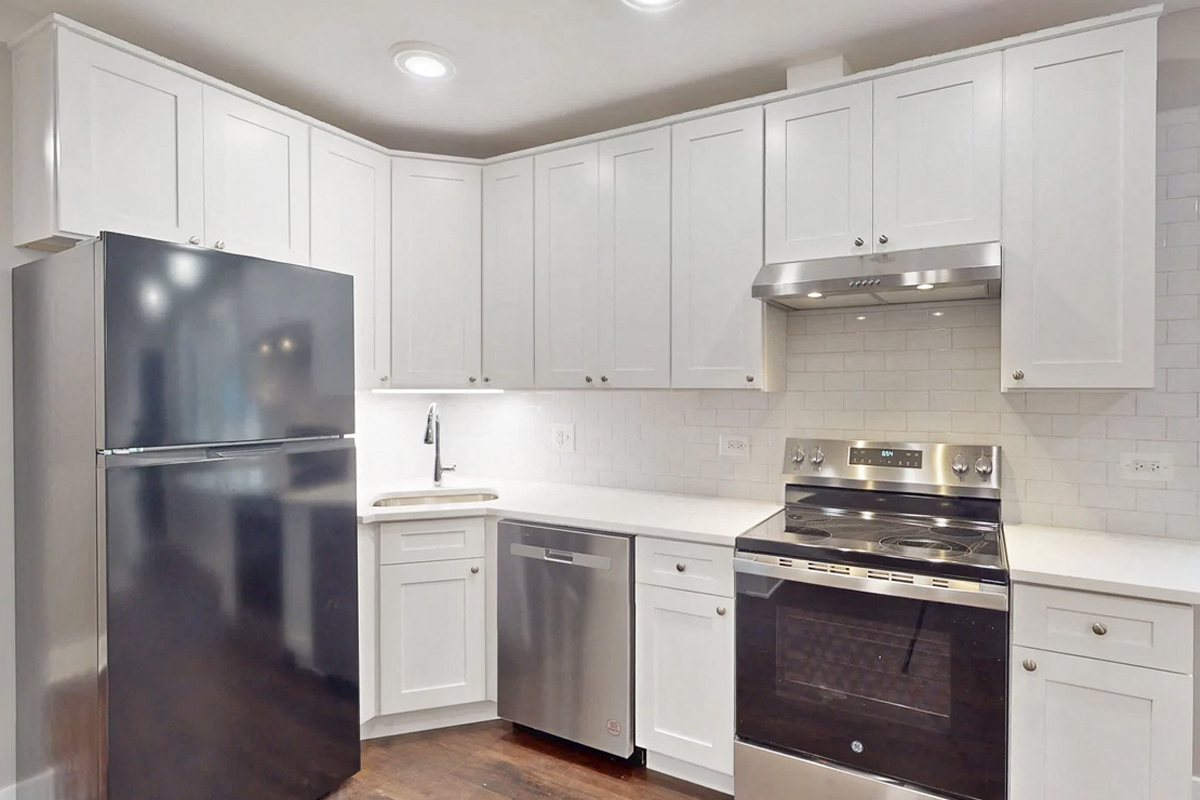a white kitchen with stainless steel appliances and white cabinets