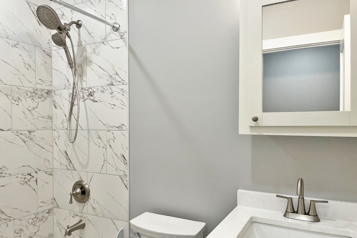 a bathroom with a shower and a sink and a mirror