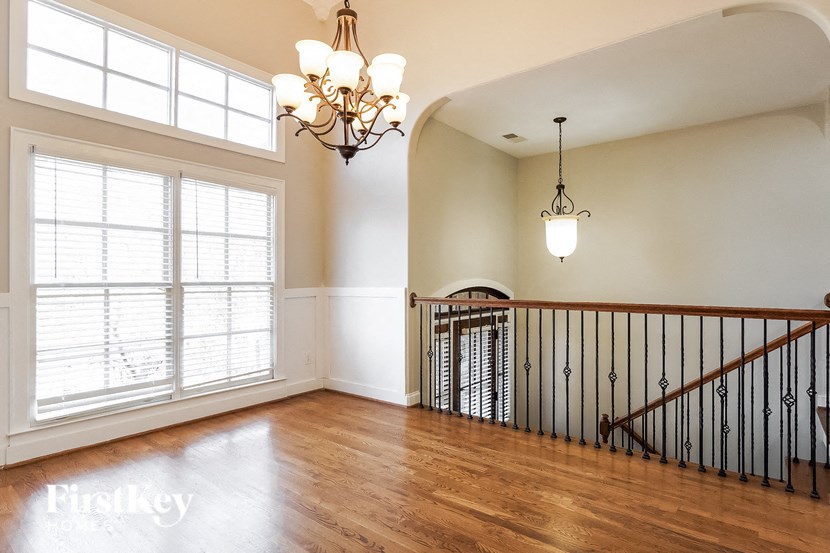A large room with a wooden floor and a staircase.