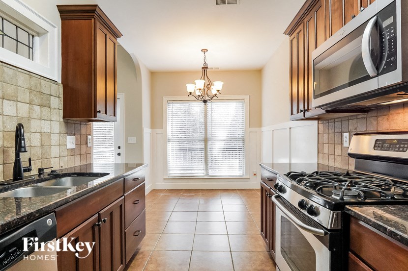 A kitchen with a stove top oven and a microwave above it.