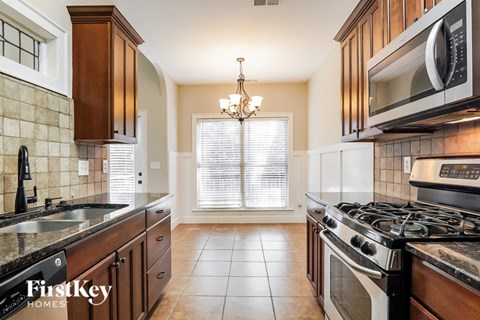 A kitchen with a stove top oven and a microwave above it.