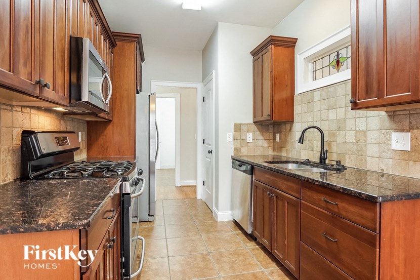 A kitchen with brown cabinets and a black stove top oven.