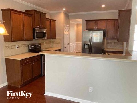 A kitchen with wooden cabinets and a refrigerator.