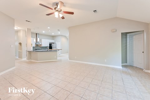 A spacious living room with a fan and tiled floor.