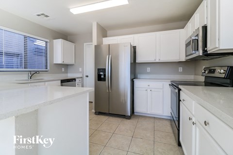 a kitchen with white cabinets and a stainless steel refrigerator