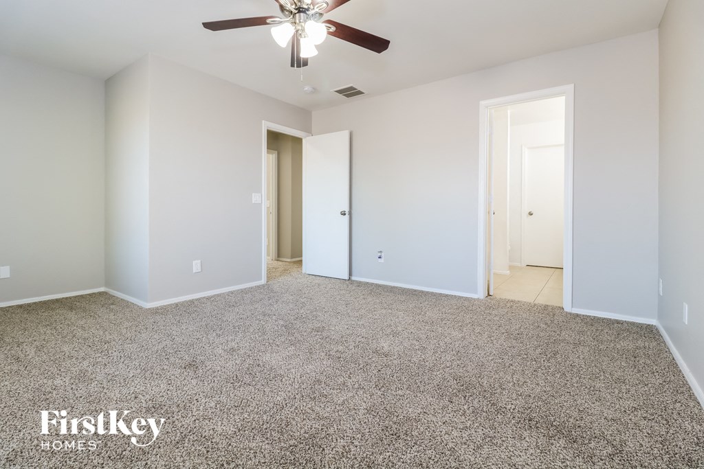 a bedroom with a carpeted floor and a ceiling fan