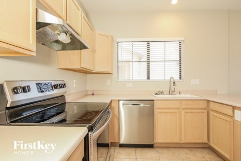 A kitchen with wooden cabinets and a stainless steel dishwasher.