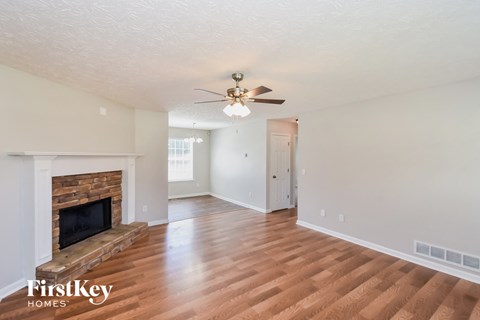 a living room with a fireplace and a ceiling fan