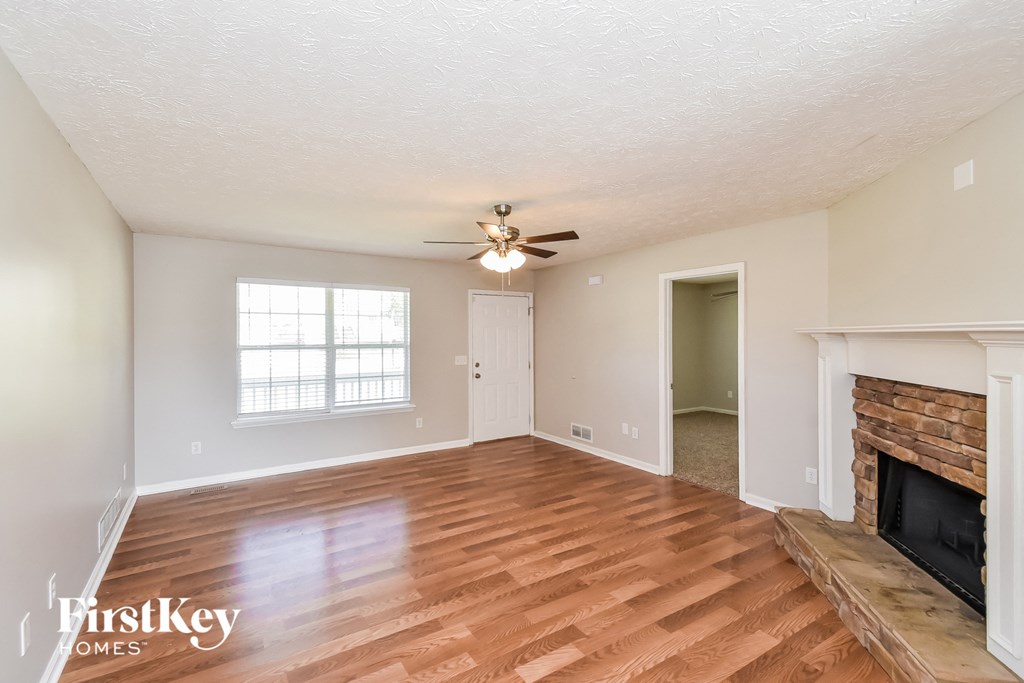 a living room with a fireplace and a ceiling fan