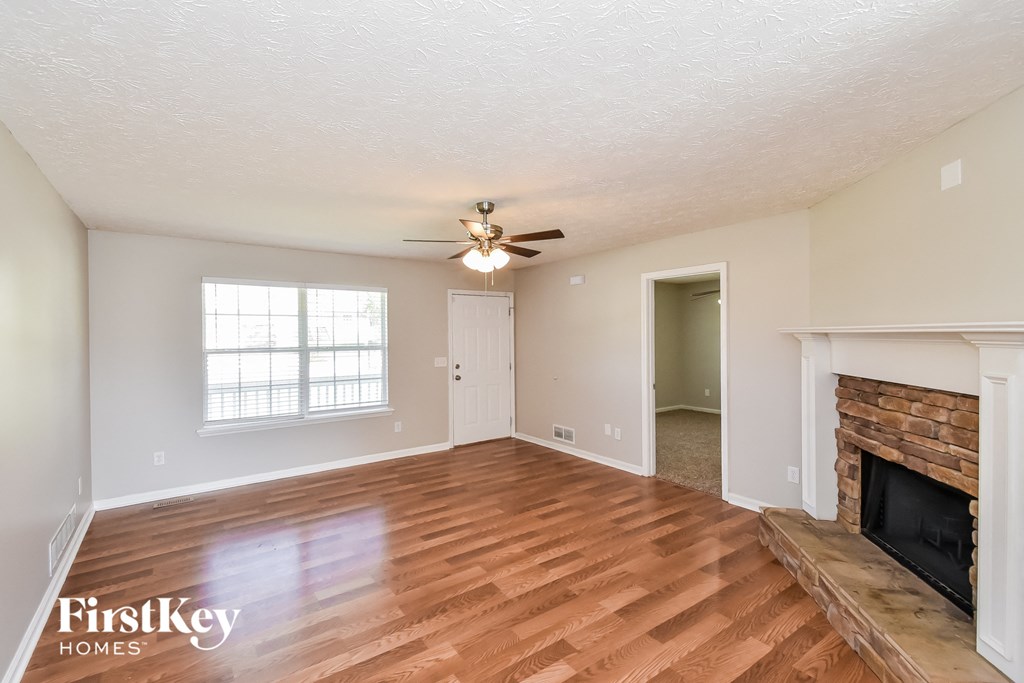 a living room with a fireplace and a ceiling fan