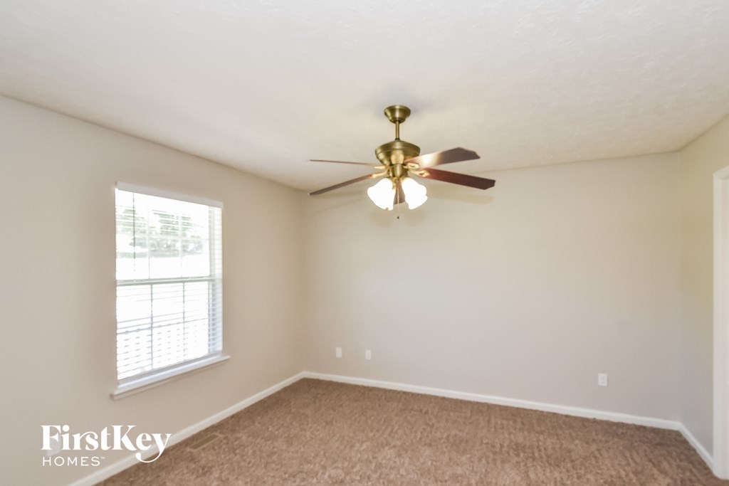 a bedroom with a ceiling fan and a window
