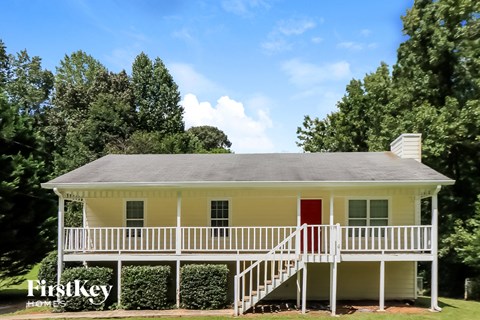 a white house with a red door and a white porch