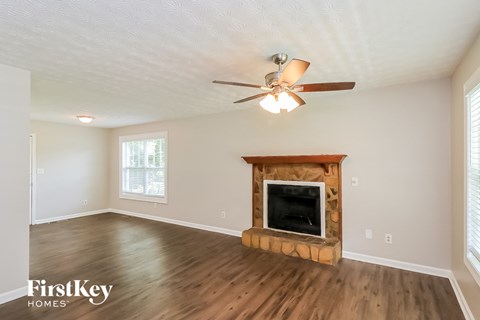 a living room with a fireplace and a ceiling fan