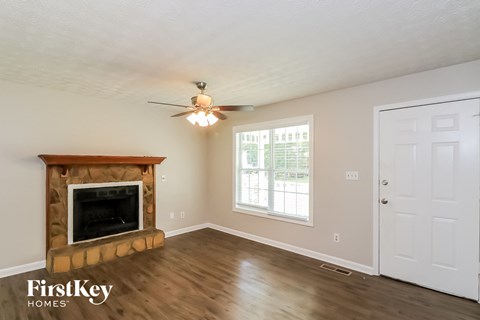 a living room with a fireplace and a ceiling fan