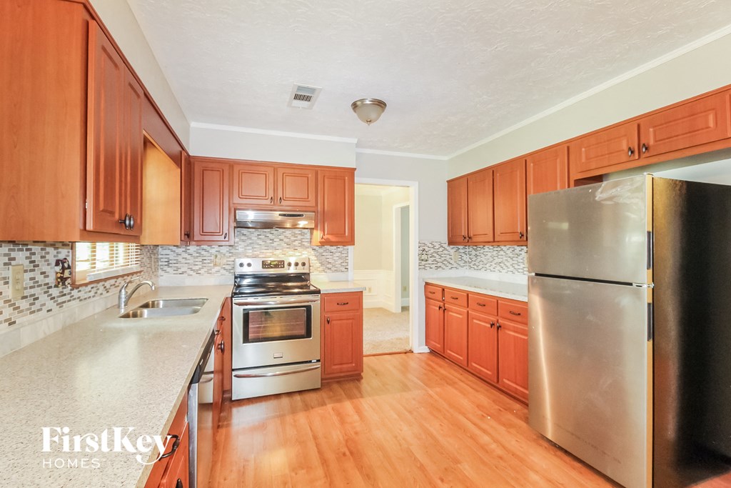 a kitchen with wooden cabinets and stainless steel appliances