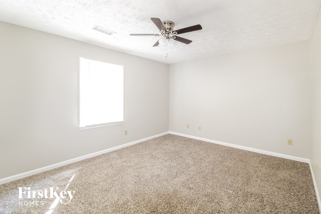 a room with carpet and a ceiling fan