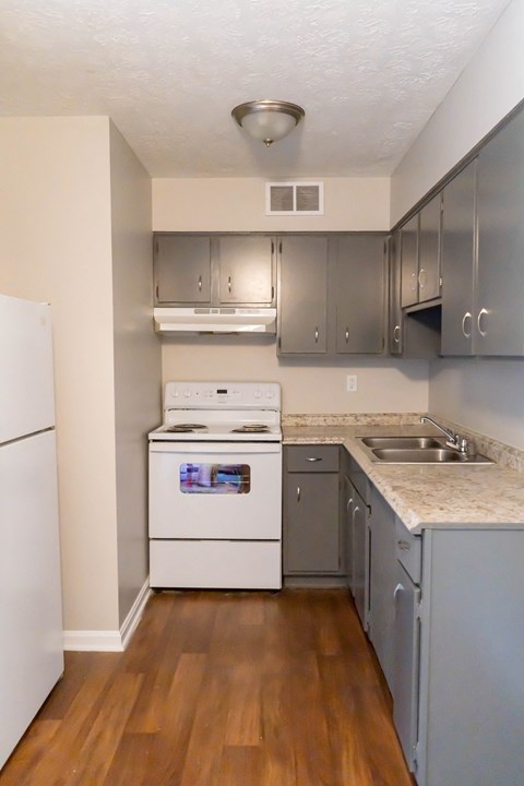 an empty kitchen with stainless steel appliances and marble counter tops