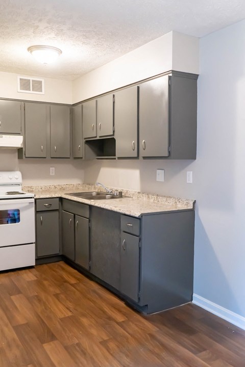 an empty kitchen with stainless steel cabinets and a marble counter top
